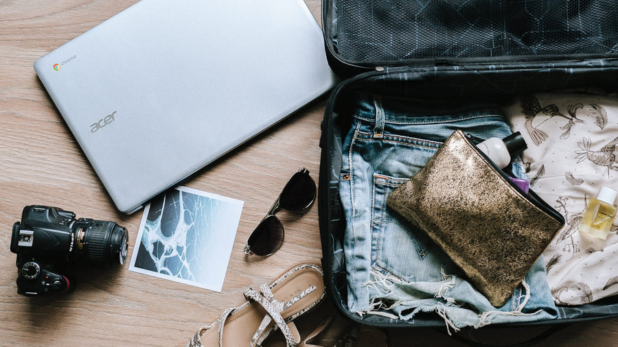 Traveler planning a trip with a laptop and phone